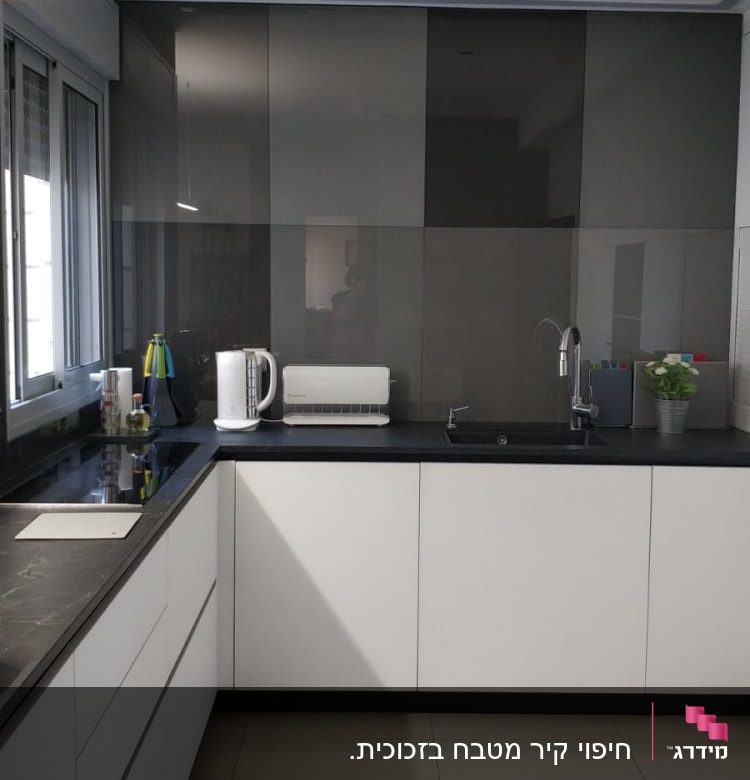 קיר זכוכית כהה במטבח מודרני עם כיור וברז